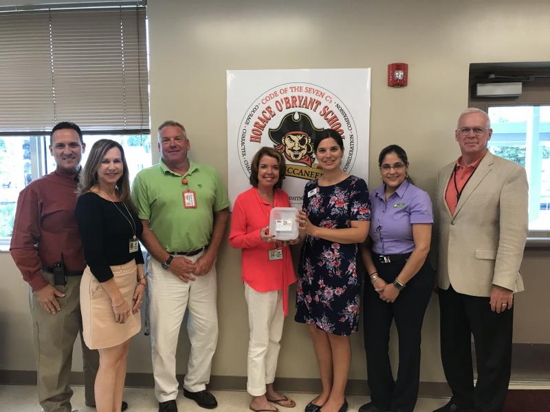 Horace O&#039;Bryant staff and Superintendent Mark Porter accept Tools for Back to School gift cards from UWFK &amp; Publix staff.